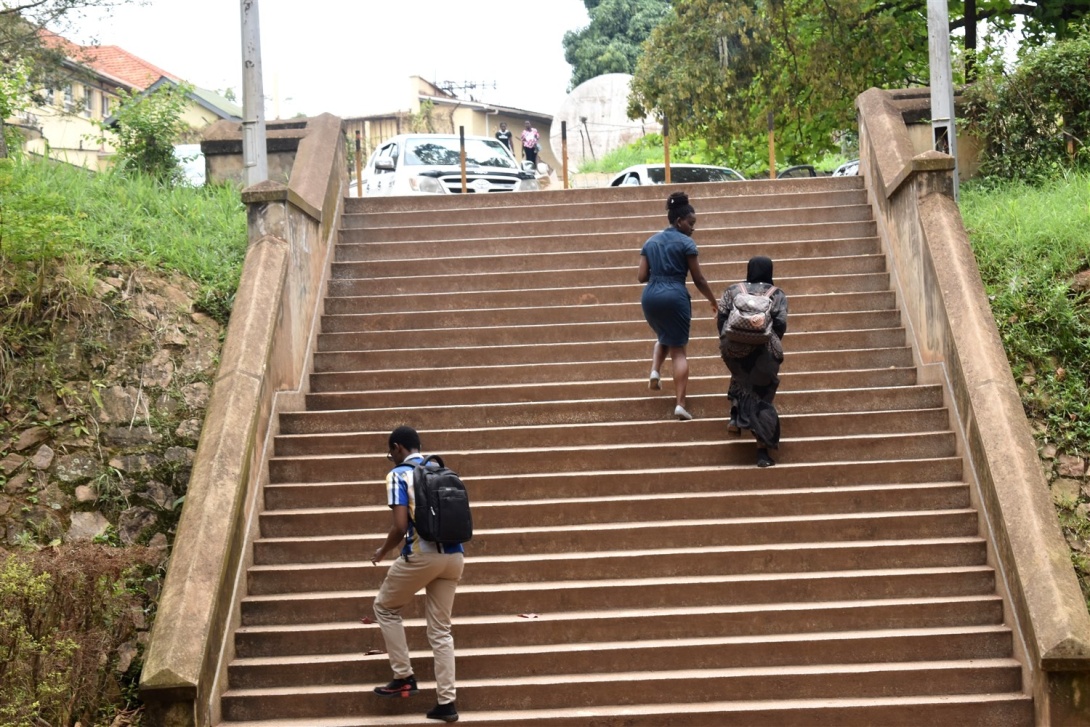 A male and two female students go up the staircase at the College of Engineering, Design, Art and Technology (CEDAT), Makerere University, Kampala Uganda, East Africa.