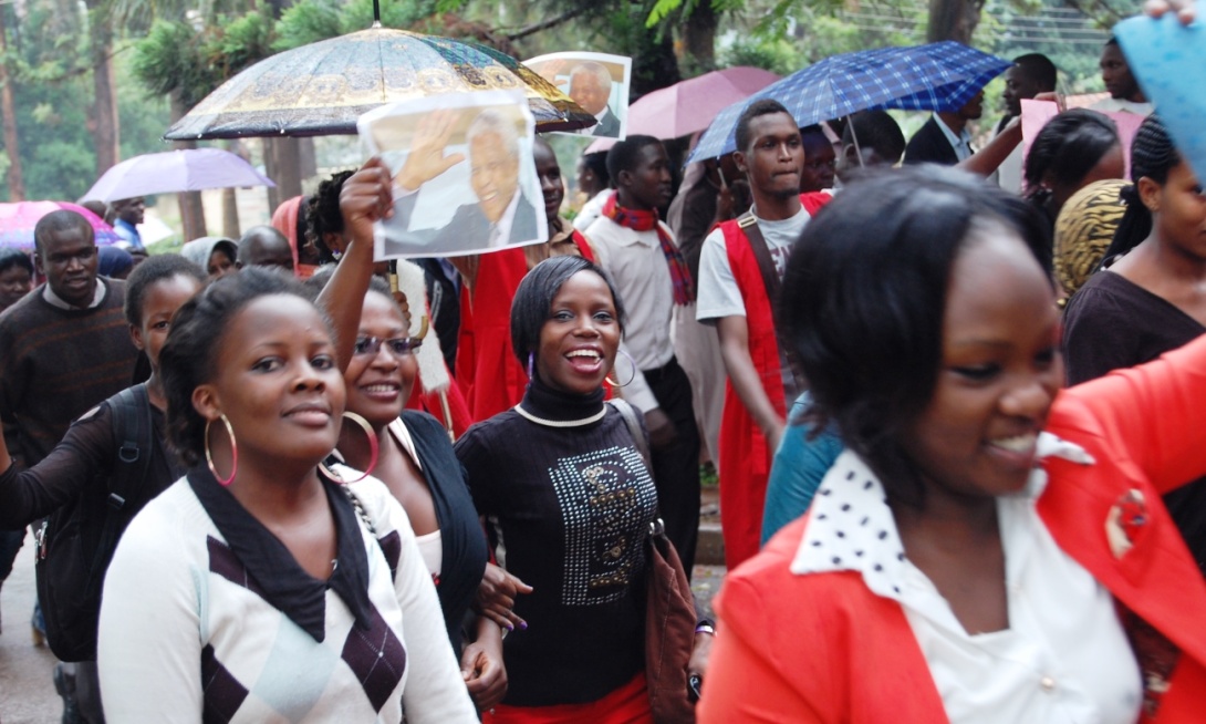 Female students smile for the camera as they take part in a March organised by the Students Guild on 11th December 2013 to commemorate the life of Nelson Mandela. Makerere University, Kampala Uganda.