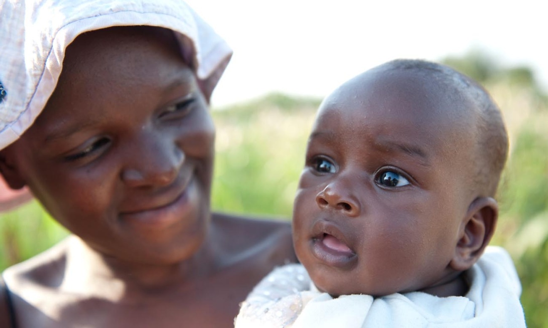 A mother and her baby smile for the camera at Makerere University Agricultural Research Institute Kabanyolo (MUARIK), CAES, Wakiso Uganda, East Africa. Date taken: 13th August 2010.